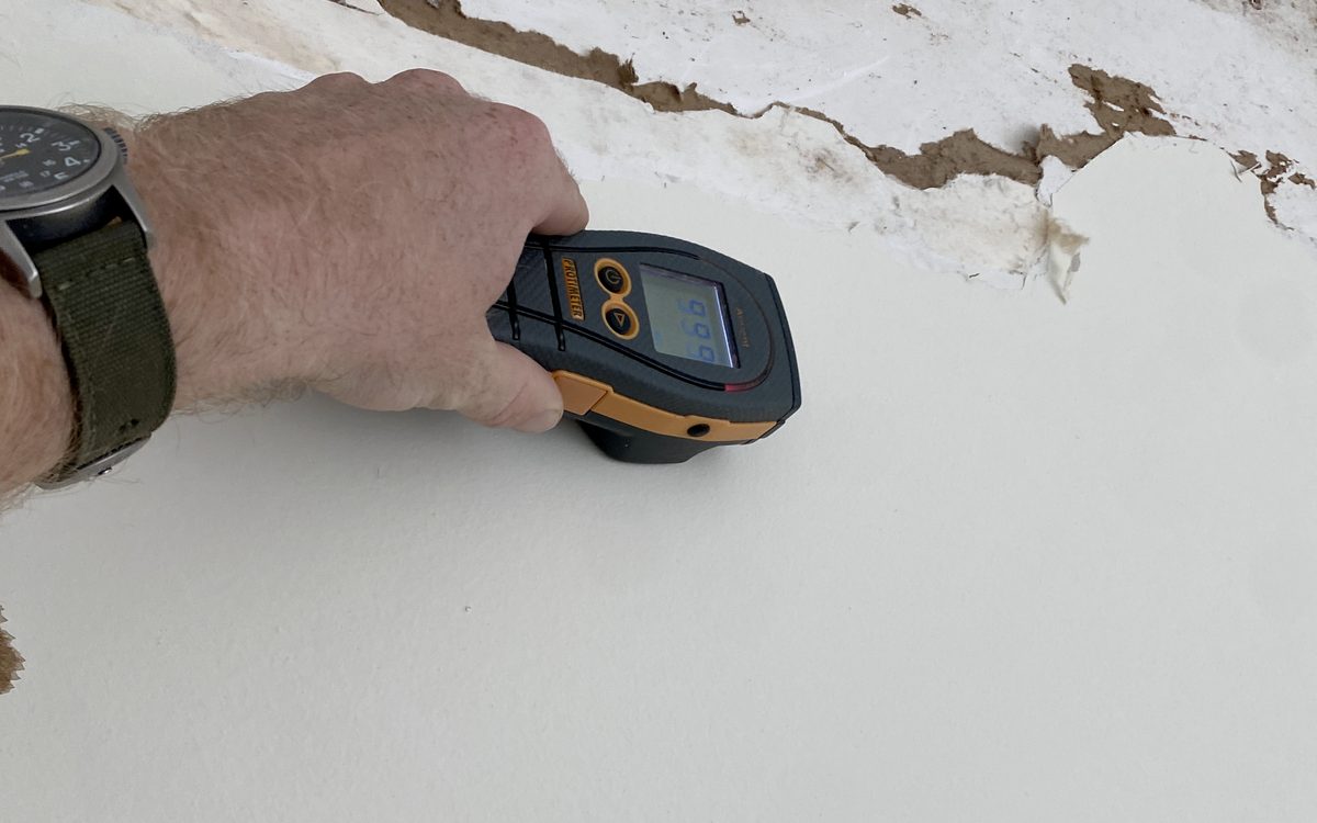 Mold inspection in Weston, FL: Infrared thermometer aimed at a wall where the drywall paper has delaminated