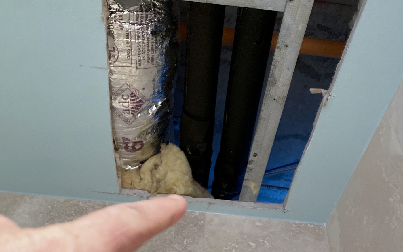 Opened ceiling in a multi-storey building exposing ductwork, insulation and the concrete deck above