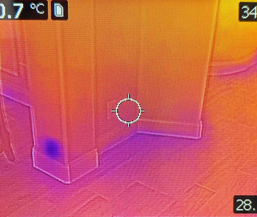 Thermal scan of a wall and floor corner showing a cold spot where moisture is present.
