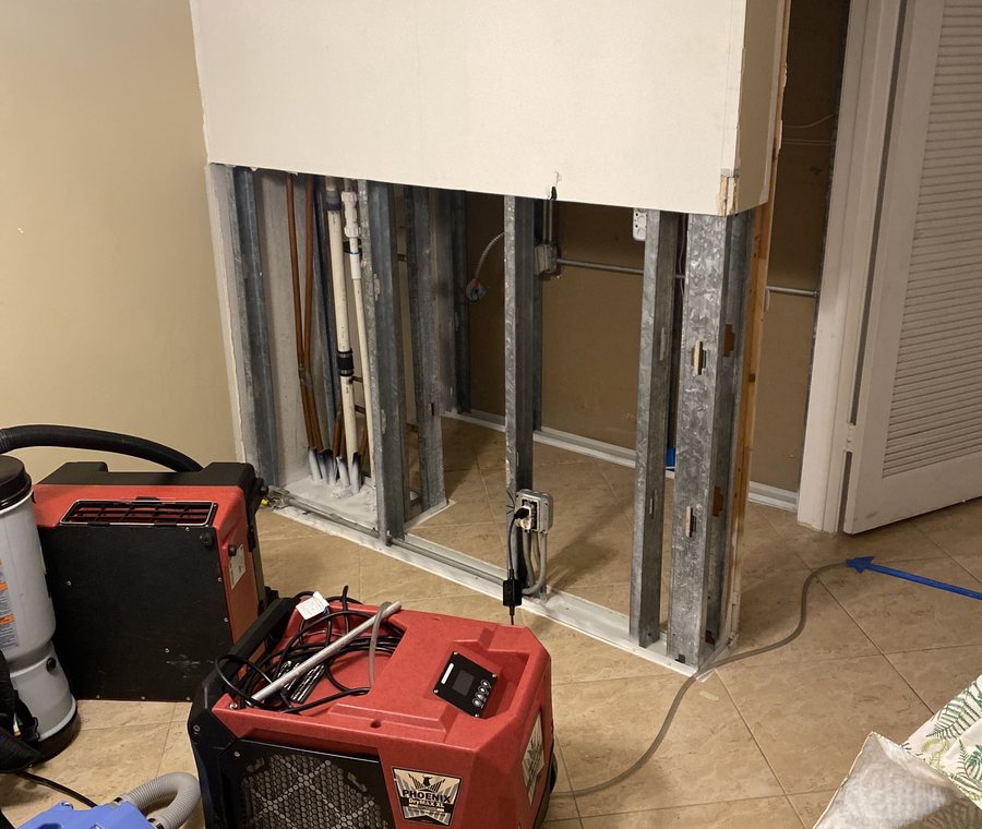 Wall opened to the studs with drying equipment running after a water loss.